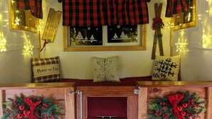 Um quarto aconchegante com um banco de madeira, uma janela com decorações festivas e um letreiro fixado na parede.