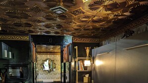 Um interior moderno com um sofá, uma área de cozinha e um teto decorativo.