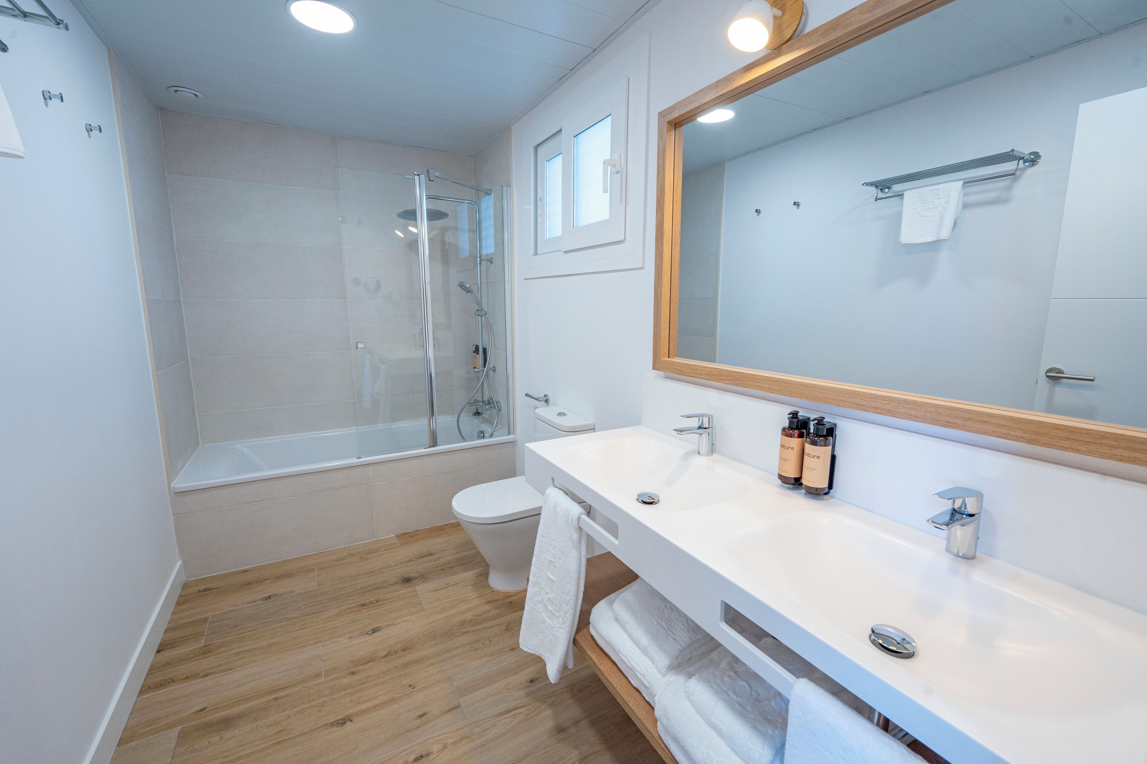 A modern bathroom with a shower, toilet, and vanity.
