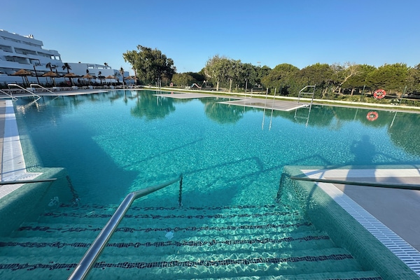 Piscina a l'aire lliure, para-sols i gandules