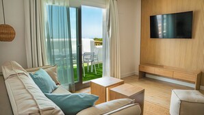 Una sala de estar moderna con un sofá, una mesa de centro y un televisor instalado en una pared de madera.
