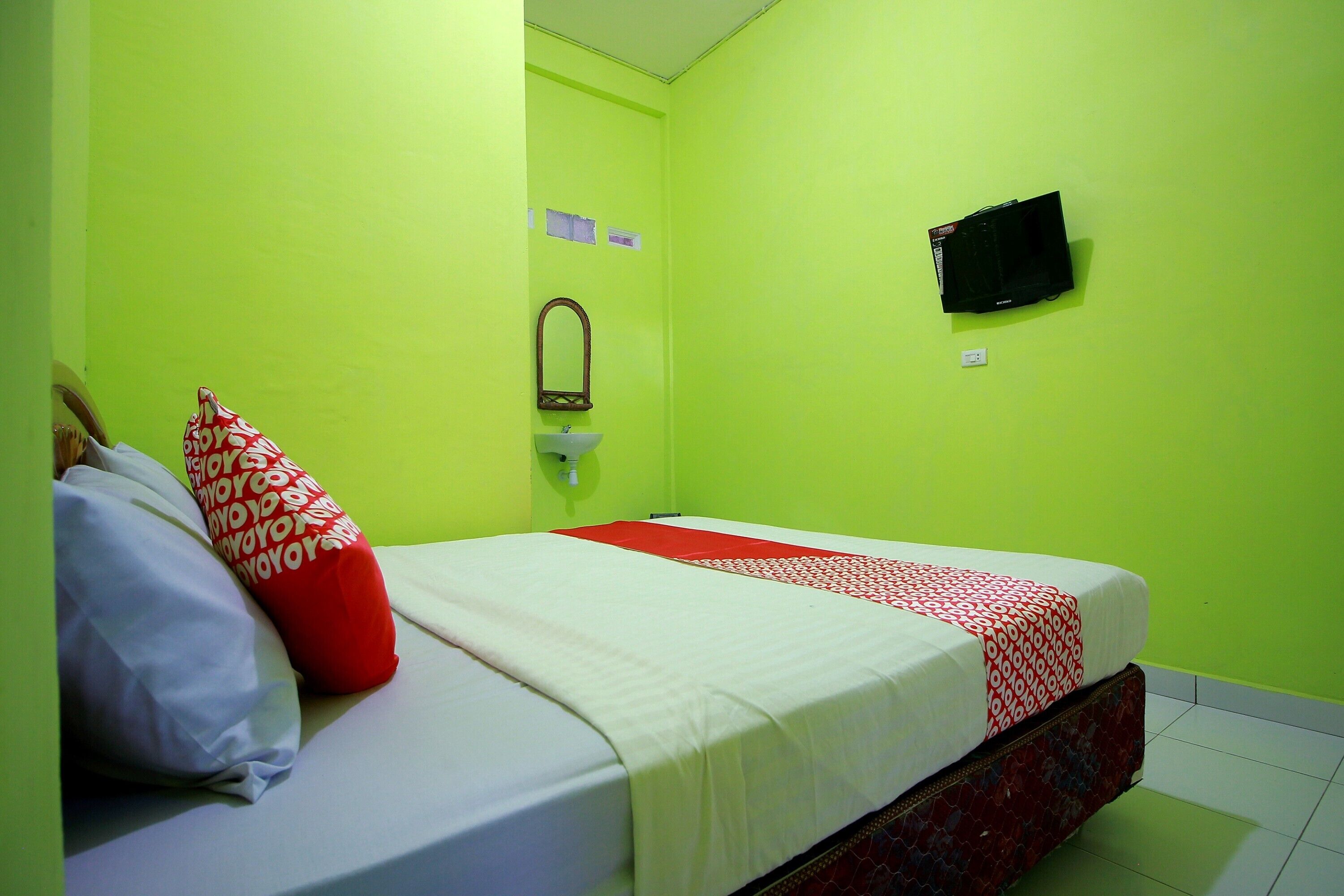 Una habitación con cama, lavamanos y televisión.