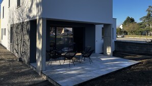 A modern house with a patio area featuring outdoor furniture. - Près Colmar 6 Dans Maison Moderne de 2023, à 10 mn de Colmar , 40 mn Europapark, (Wolfgantzen)