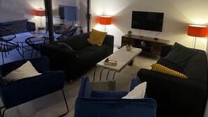 A modern living room with a sofa, chairs, a coffee table, and a TV. - Près Colmar 6 Dans Maison Moderne de 2023, à 10 mn de Colmar , 40 mn Europapark, (Wolfgantzen)