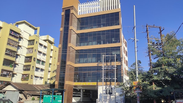 Un hotel de varios pisos con fachada de vidrio moderna, un letrero llamativo que dice 