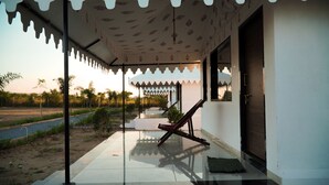 Un espacio al aire libre cubierto con una silla, una puerta y un techo estampado.