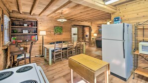 A rustic wooden cabin interior with a dining area, kitchen, and a refrigerator. - Blairsville Cabin w/ Fire Pit, 7 Mi to Dtwn! (Blairsville)