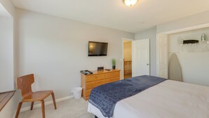 A bedroom with a bed, a wooden dresser, a television, and a door leading to another room. - Antioch Townhome < 14 Mi to Downtown Nashville! (Antioch)