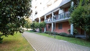 A building with a brick facade, multiple balconies, and a paved pathway. - La Cà del Lori (Milano)