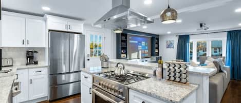 Enjoy cooking in this well-equipped kitchen with a central island, refrigerator, oven, and stove.