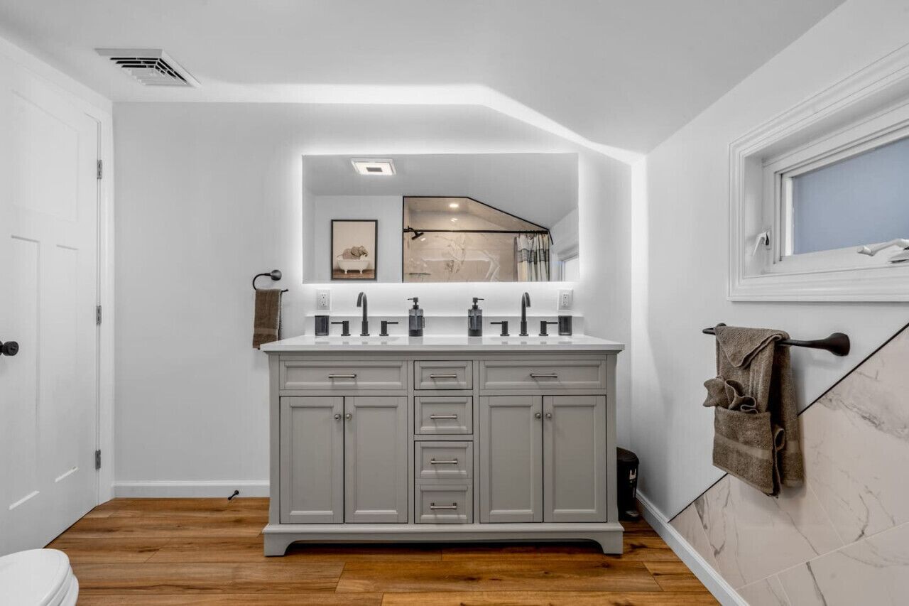 A bathroom with a large vanity, a mirror, and a window.