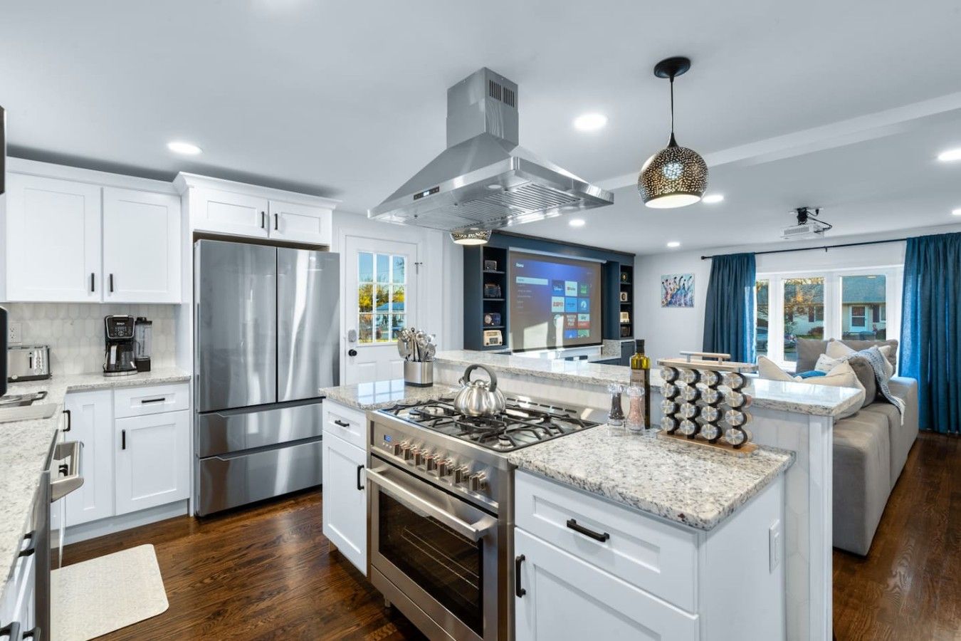 A modern kitchen with stainless steel appliances, a central island, and a built-in oven.