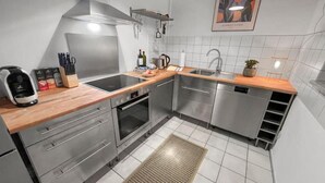 A modern kitchen with stainless steel appliances, wooden countertops, and a tiled backsplash. - Beckhomes: Luxuriöses Juwel Mitten in der Altstadt (Bamberg)