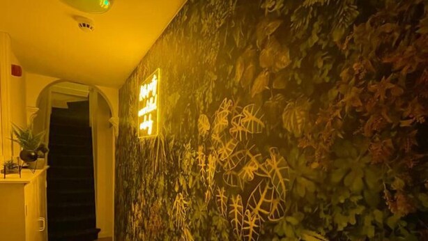 A hallway with a textured wall and a neon sign. - Apartment in Leeds Close to City Centre (Leeds)