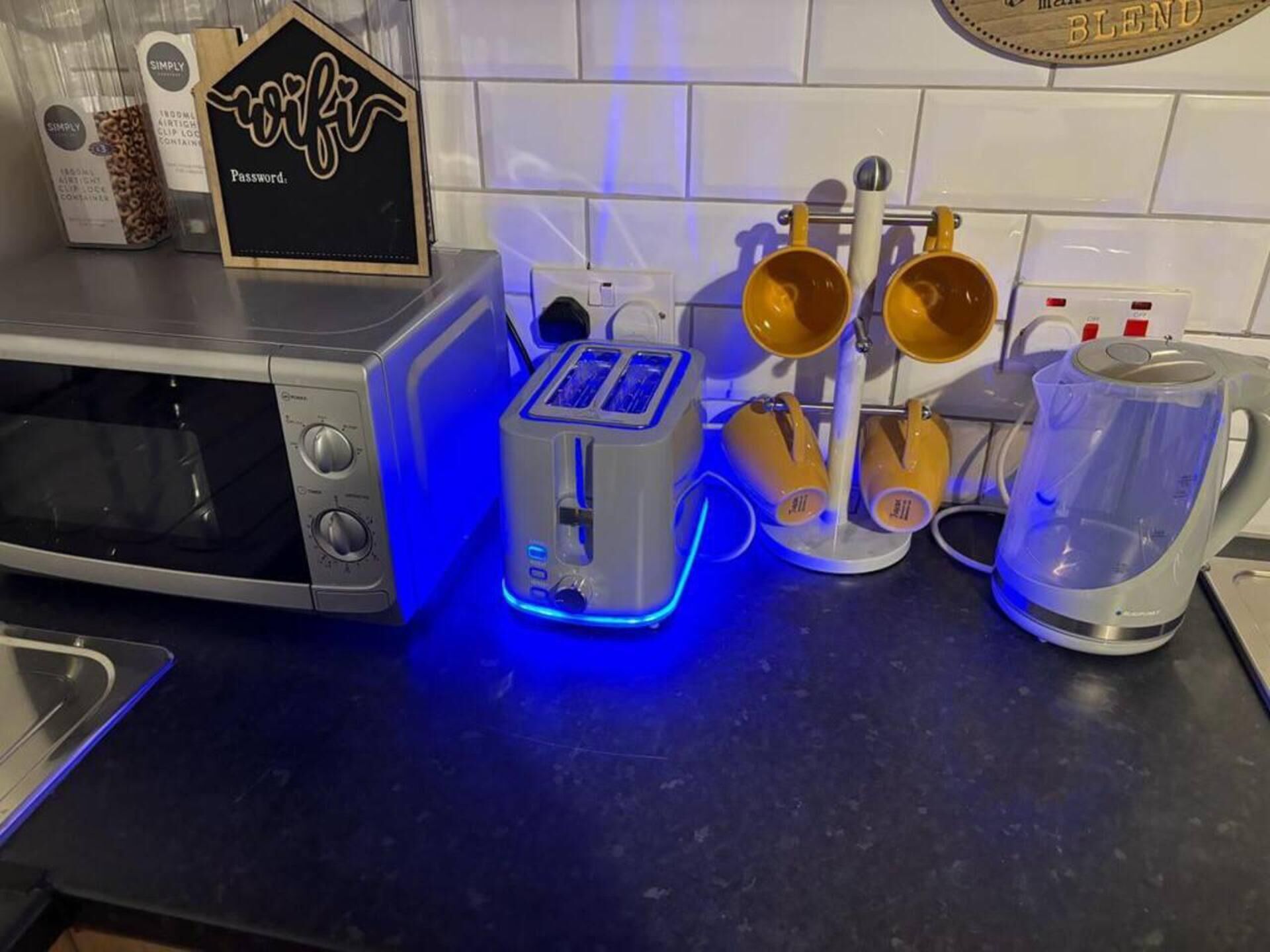 A kitchen with a microwave, toaster, and coffee maker.