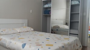 Et soveværelse med en seng, et skab og et natbord.