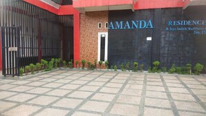 A building entrance with a tiled pavement, a black gate, and a sign that reads "AMANDA RESIDENCE." - SPOT ON 93478 Amanda Residence Syariah (Palembang)