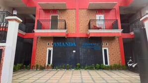 A two-story building with a red facade and a sign reading "AMANDA RESIDENCE." - SPOT ON 93478 Amanda Residence Syariah (Palembang)