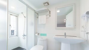 Et moderne badeværelse med bruser, toilet og håndvask.