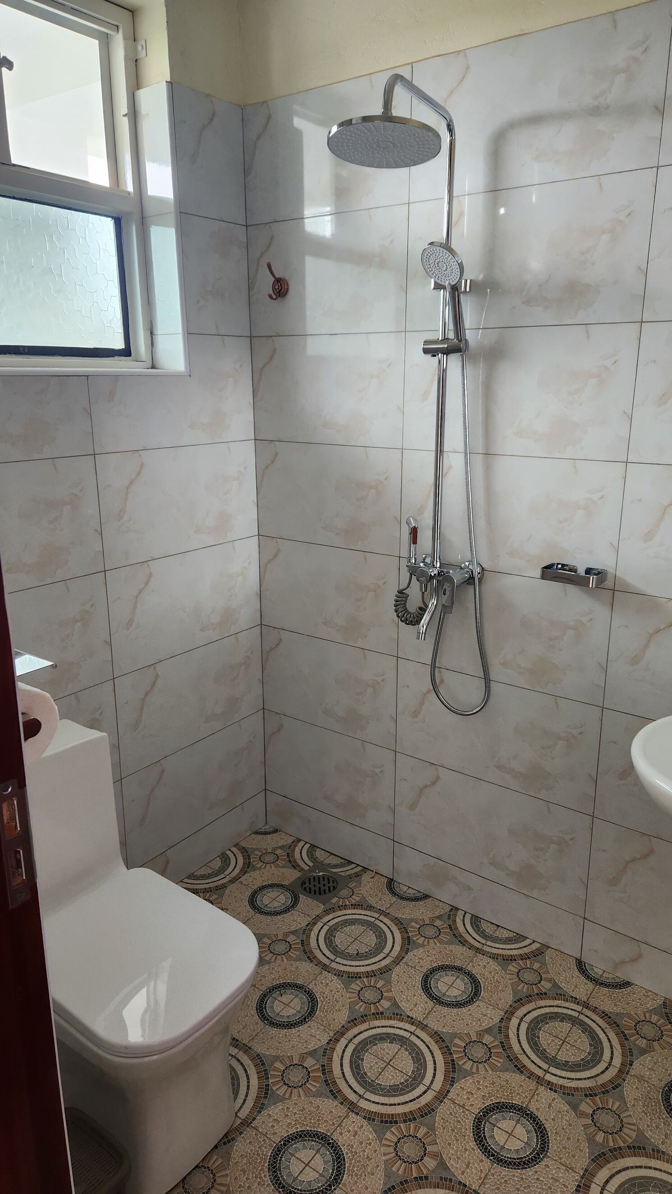 A bathroom with a shower, toilet, and sink.