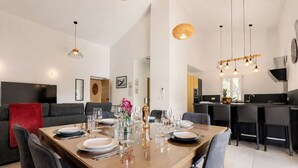 Un espace de restauration moderne avec une table en bois dressée pour six personnes, entourée de chaises grises.