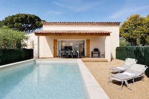 Ein Pool mit Terrasse, überdachter Sitzgelegenheit und Blick auf die umliegende Landschaft.