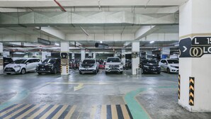 A multi-level underground parking garage with clearly marked lanes and directional arrows. - Capital O 93490 Yubi Room Patraland  (Bekasi)