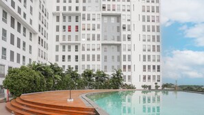 A modern building with a pool and steps leading to a terrace. - Capital O 93490 Yubi Room Patraland  (Bekasi)