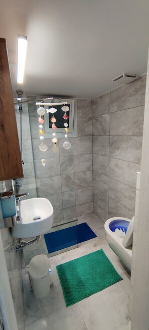 Une salle de bain équipée d’un lavabo, de toilettes et d’une douche.