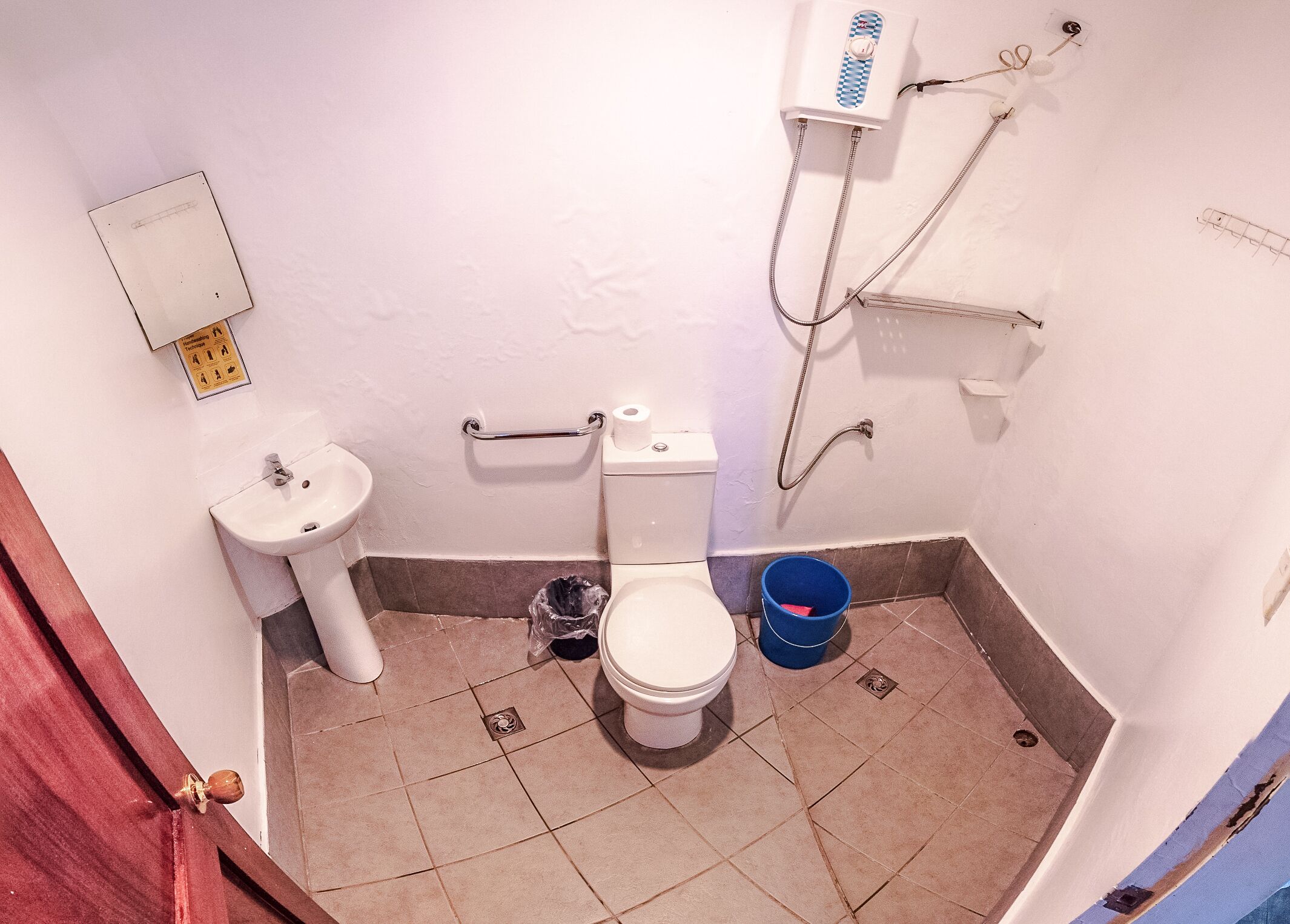 Un baño pequeño con inodoro, lavamanos y ducha.