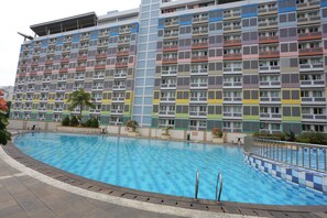 A multi-story hotel with a swimming pool. - OYO 93492 Mamiya Rooms  (Depok)