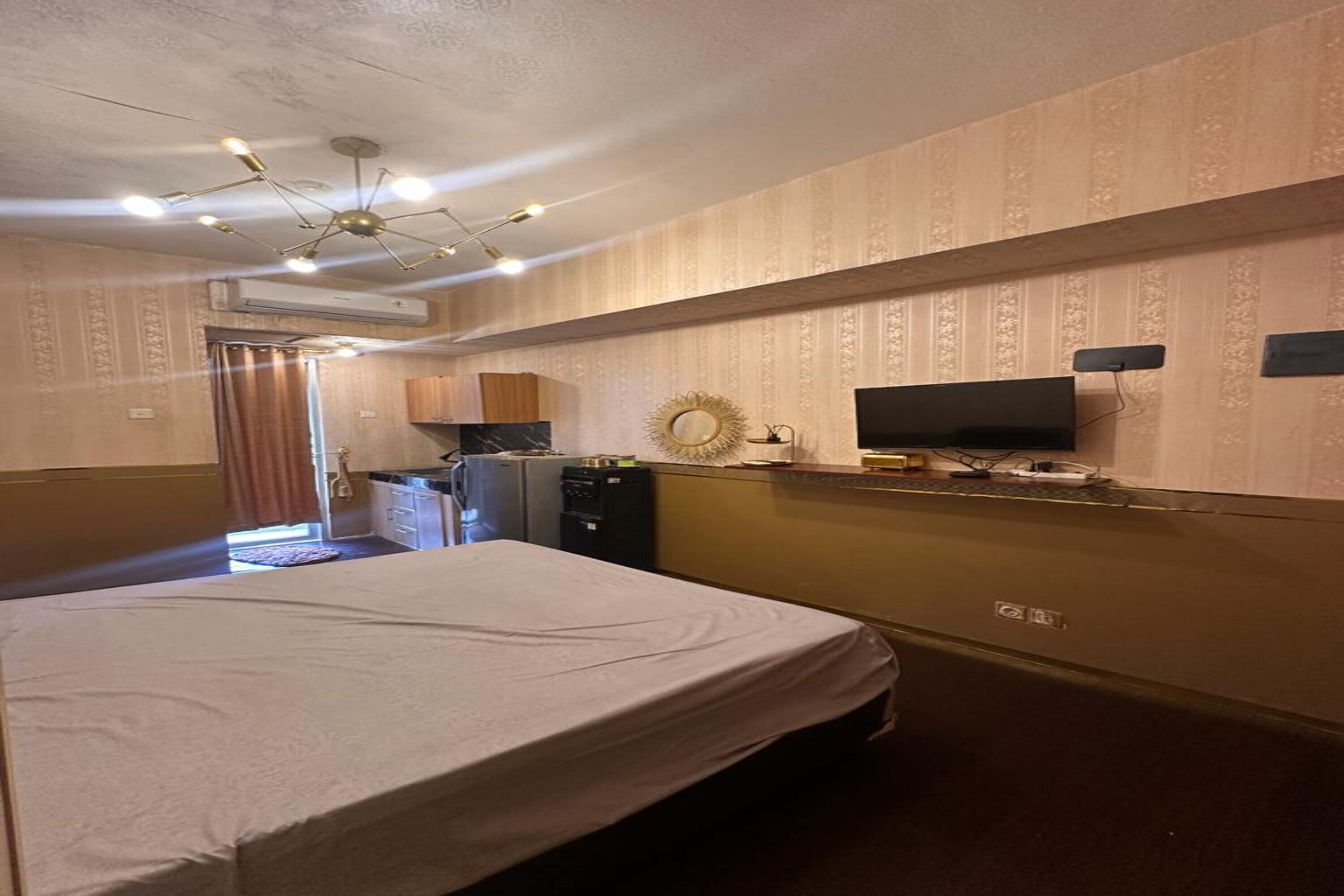 A hotel room with a bed, a television, a desk, and a wardrobe.