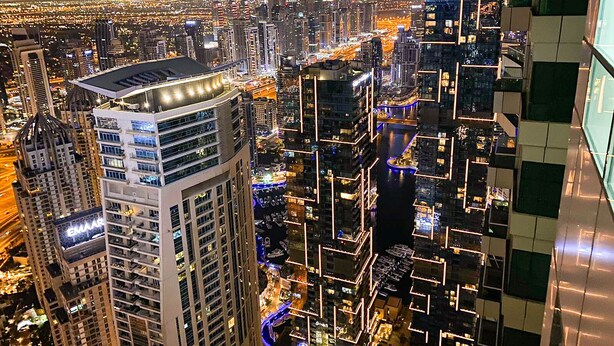 A high-rise building with a modern design, featuring multiple floors and a prominent rooftop structure. - Hawana Premium Hostel (Dubai)