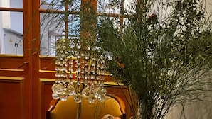 A dining table with a plate of fruit, a glass of water, and a menorah. - Bali Star City Hotel (Istanbul)