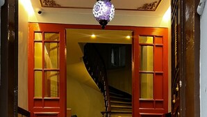 A grand staircase with ornate railings and a patterned carpet leading to a landing with a chandelier. - Bali Star City Hotel (Istanbul)