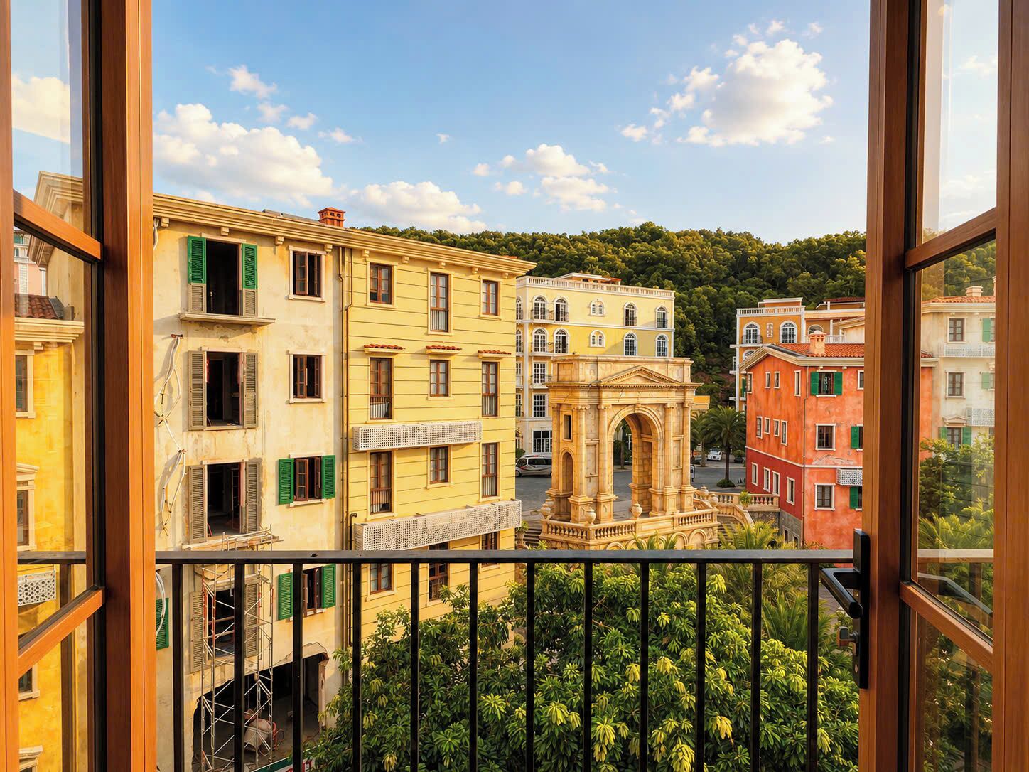 A balcony with a view of colorful buildings, a central archway, and lush greenery.