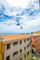 Un sistema de teleférico sobre una ciudad costera con edificios de tejados de teja.