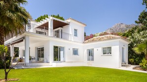 A two-story house with a balcony, large windows, and a well-maintained lawn. - Buccara Casa Bruno (Marbella)