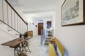 Staircase leads to an upper floor, featuring a vintage sewing machine and classic decor.