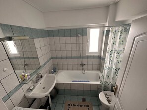 A bathroom with a bathtub, a sink, and a toilet. - VerGian Brand New Apt at Agioi Theodoroi (Loutraki-Agioi Theodoroi)