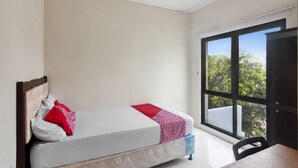 A bedroom with a bed, a window, and a view of greenery outside. - OYO 93500 Rizki Residence TOS Syariah Near PT Bank KB Bukopin Tbk (Jakarta)