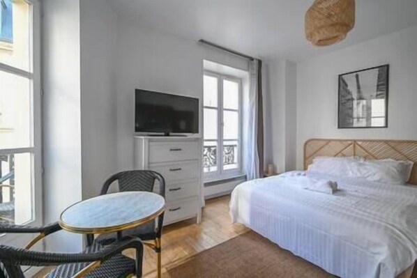 Une chambre d’hôtel comprenant un lit, une télévision, une table et une chaise.