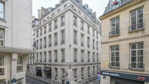 A corner building with multiple stories, large windows, and a storefront labeled "MISTER GARDEN". - Paris, Opéra 1... Comme Chez soi (Paris)