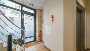 Ein modernes Interieur mit Treppe, Feuerlöscher und Aufzug.