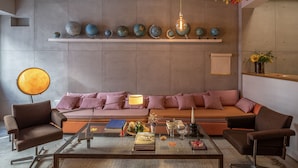 A modern living room with a sofa, coffee table, and decorative globes on shelves. - toctoctocLisboa (Lisbon)