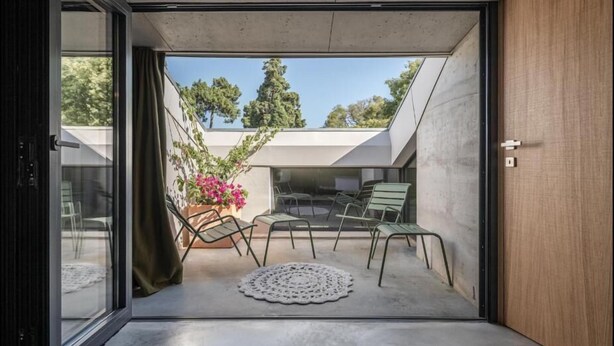 A modern interior with a sliding glass door leading to an outdoor patio area. - toctoctocLisboa (Lisbon)