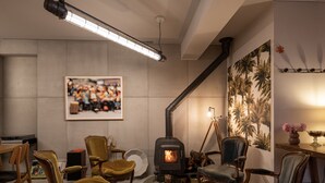 A cozy living room with a fireplace, comfortable seating, and a large framed picture on the wall. - toctoctocLisboa (Lisbon)