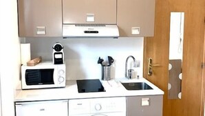 A compact kitchen with a microwave, sink, and washing machine. - Magnifique appartement à Opéra (Opéra6D) (Paris)