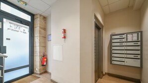 A hotel lobby with a fire extinguisher, a fire alarm, a mail drop box, and an elevator. - Magnifique appartement à Opéra (Opéra6D) (Paris)
