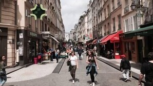 A street with buildings, shops, and people walking. - So cute typical french apartment (Paris)